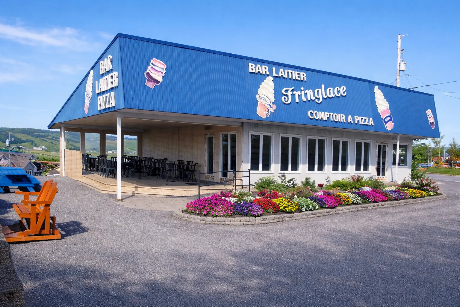 Le Fringlace — bâtiment avec peinture neuve, fleurs et terrasse